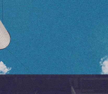 Two chimney stacks reach a blue sky.