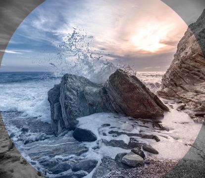 An image of a wave crashing against a rocky shore