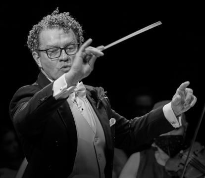 An orchestra conductor waving a baton.
