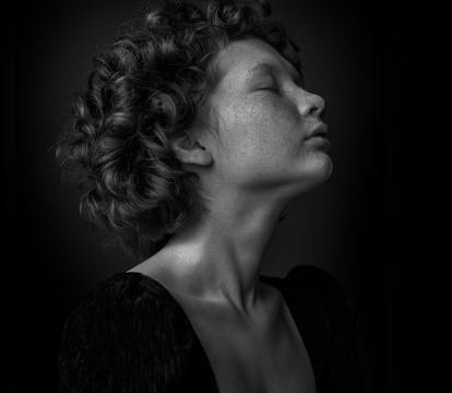 A woman with curly hairs and speckle on the face.