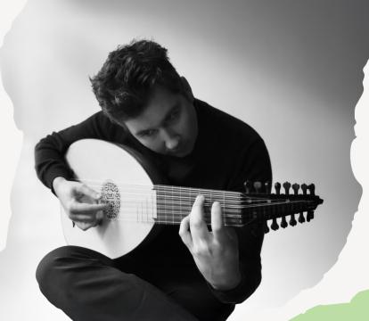 Black and white image of a man playing a lute, deeply focused.