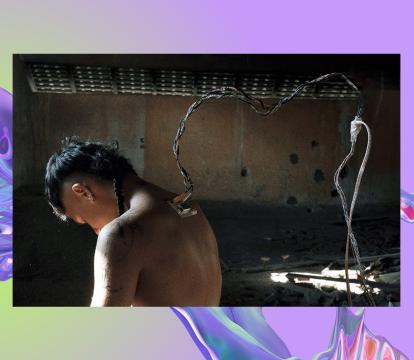 A person is standing with their head down. They have an outlet with wires connected on their upper back.