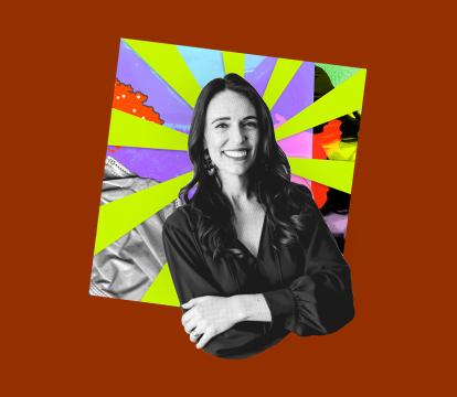 Black and white image of a smiling woman with crossed arms, set against a vibrant, multicolored background.