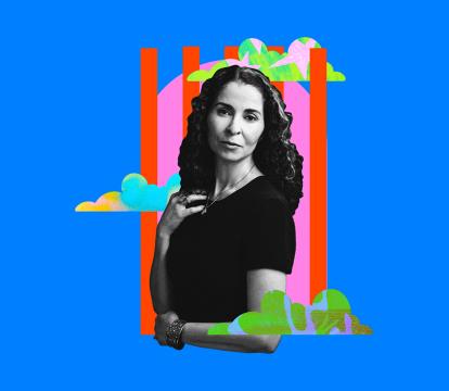 Woman in black and white with curly hair stands confidently, set against a vibrant blue background.