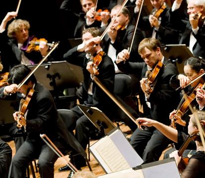 A conductor leads an orchestra on stage at the Sydney Opera House