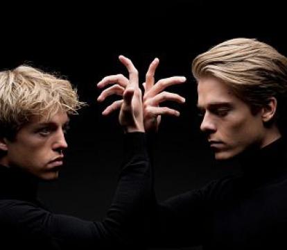 Lucas and Arthur Jussen stand in front of each other with hands raised.