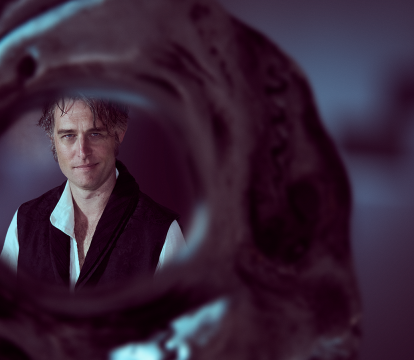 A man looking through a skeleton eye hole.