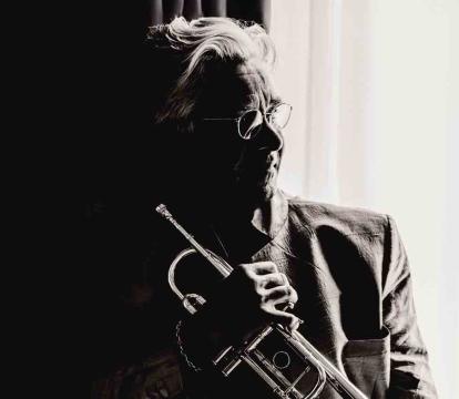 Håkan Hardenberger holds a trumpet in dramatic black and white lighting.