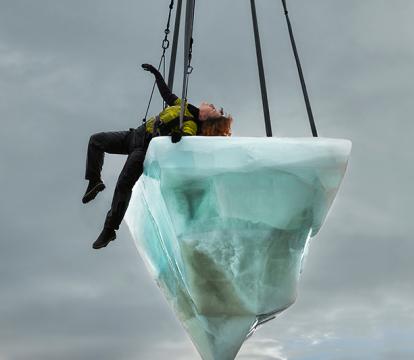 A performer lies down on a hanging iceberg on the Opera House.