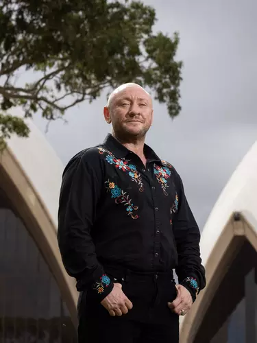 Beau James wearing an embroidered black shirt outside Sydney opera house.