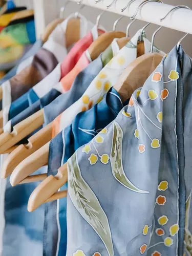 A collection of colorful material hanging from coat hangers.