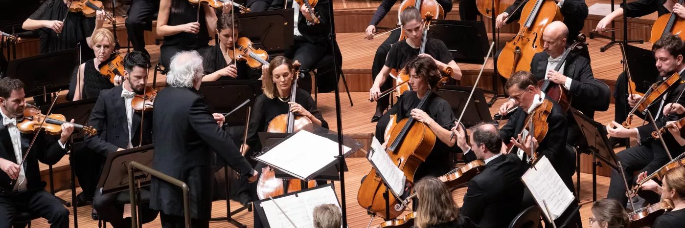 Donald Runnicles stands with baton in his left hand as he conducts the Sydney Symphony Orchestra