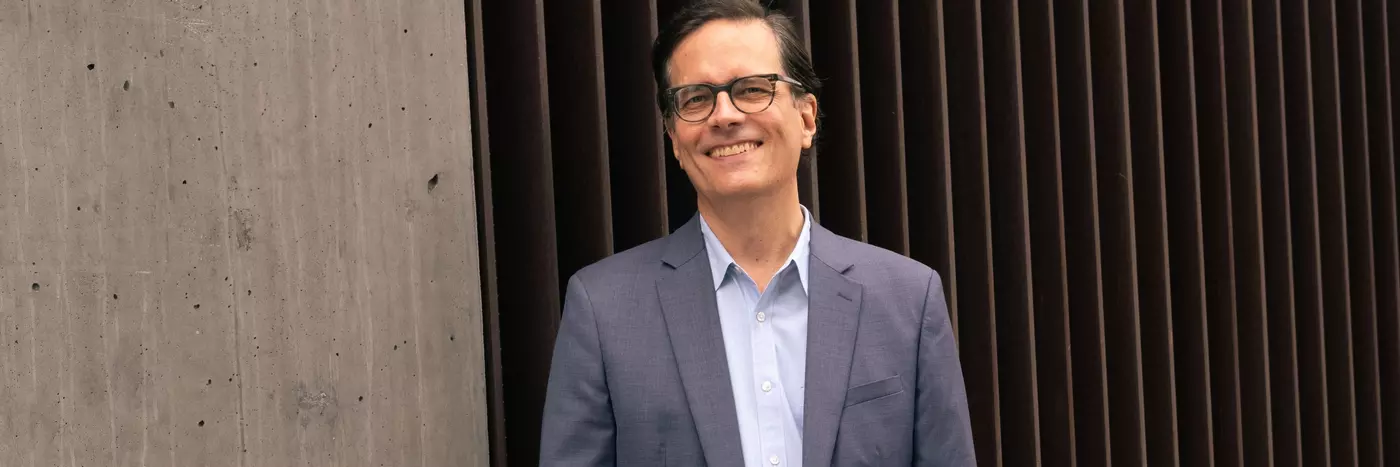 A man with short black hairs wearing a suit.