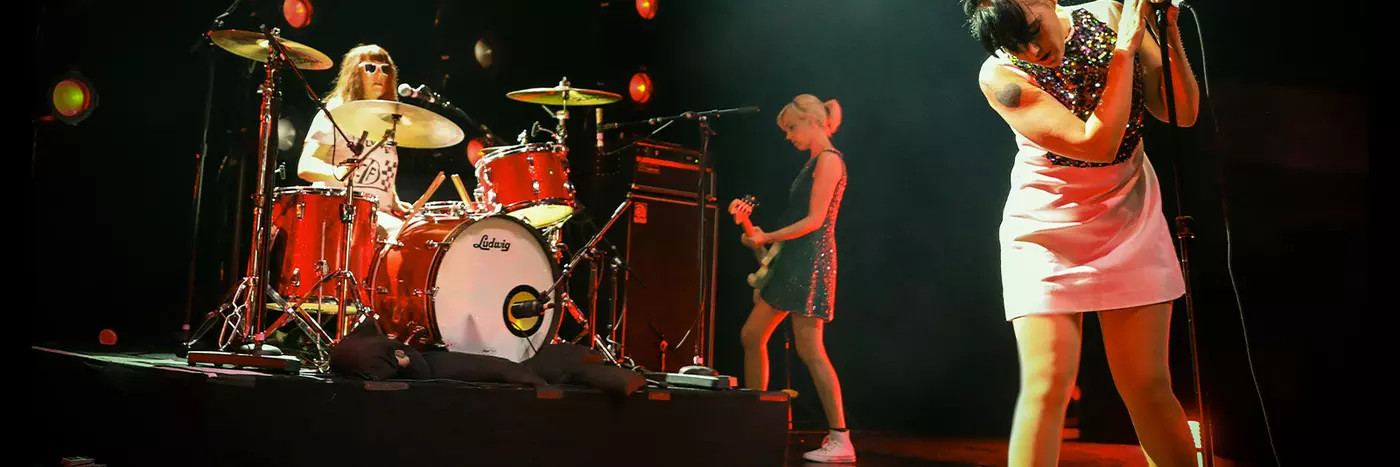 Bikini Kill a rock band performing on the stage.