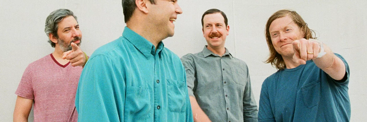 Four men from a pop band Future Islands standing together.