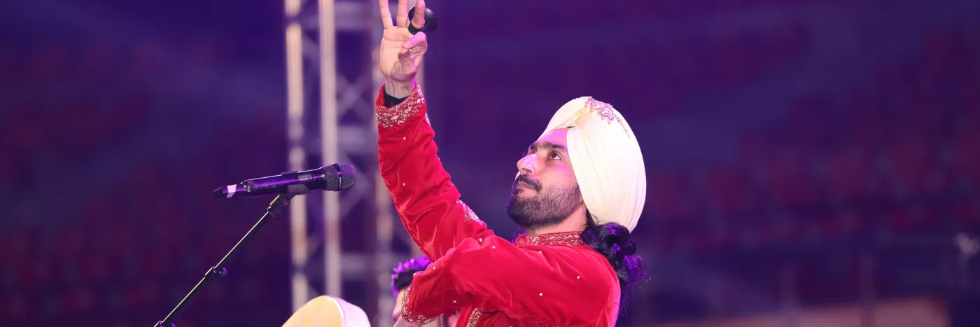 A man in a turban holds a microphone