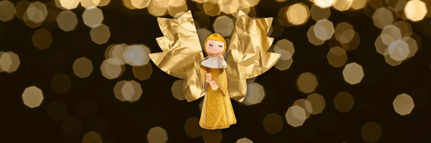 A golden doll of a Christmas Caroler with paper angel wings