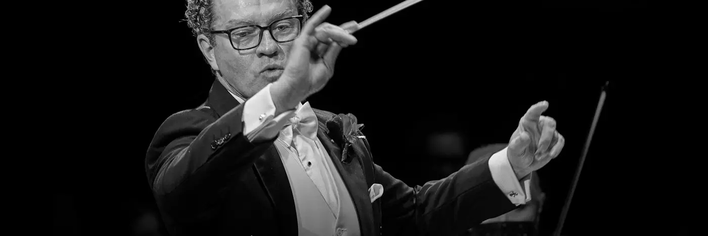 An orchestra conductor waving a baton.