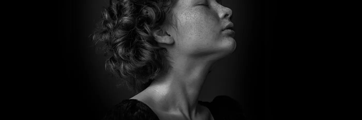 A woman with curly hairs and speckle on the face.