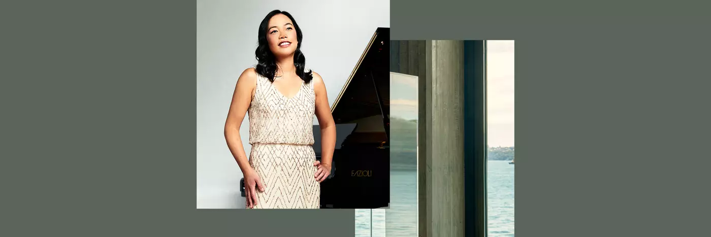 Andrea Lam a talented pianist standing close to a grand piano in a white dress.