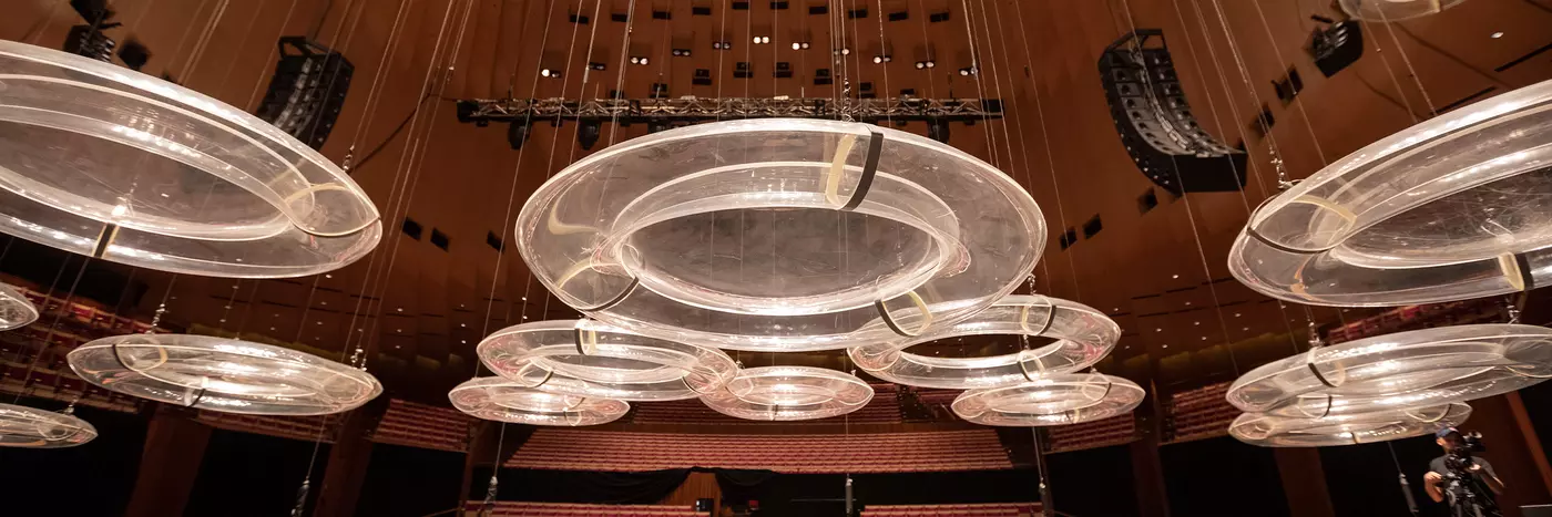 Looking up at many clear perspex discs hanging from the ceiling of the Concert Hall.