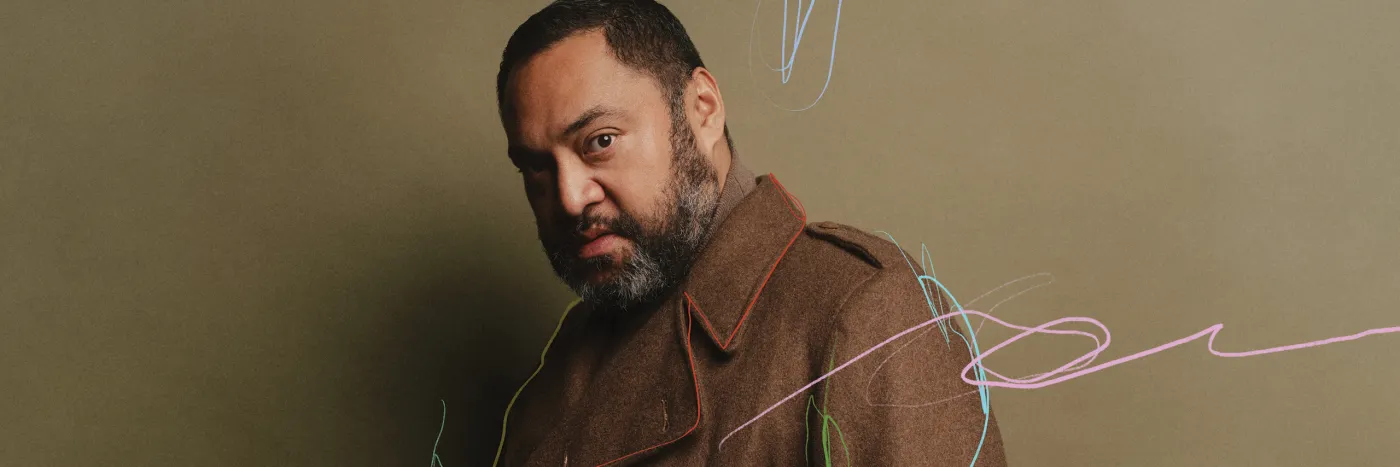 A man wearing a brown wool coat looking sidelong against a olive green background with subtle scribbled marks in pink, red, light blue and green.