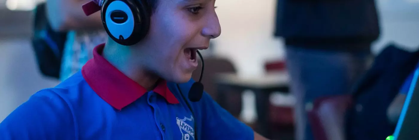 A boy on computer wearing a headset.