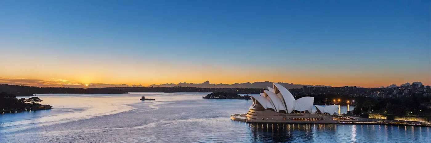 A long shot of the Sydney opera house at sunset.
