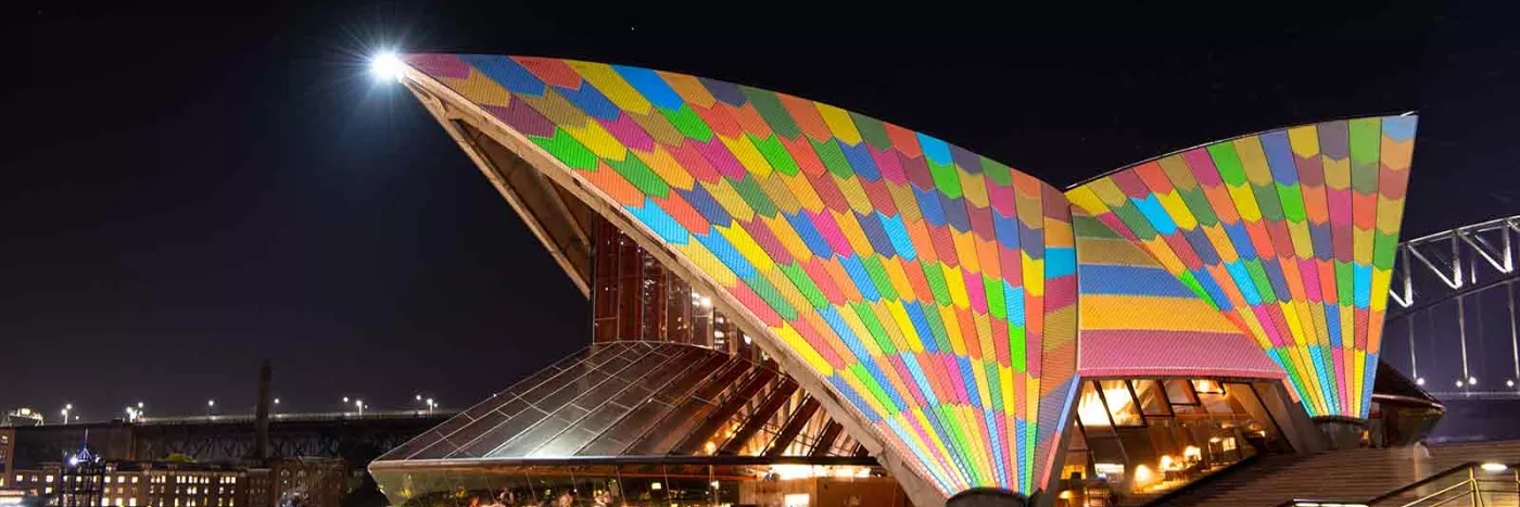 The Sydney Opera House's sails illuminated by colorful squares.