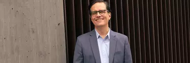 A man with short black hairs wearing a suit.