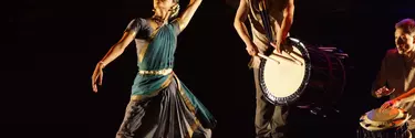 A woman in an Indian saree dancing to the sound of a Japanese drum
