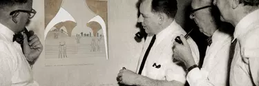 Four men looking at a drawing.