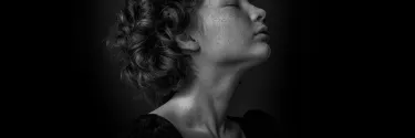 A woman with curly hairs and speckle on the face.