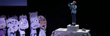A girl speaking through a megaphone on the stage.