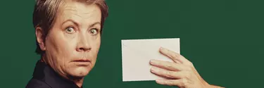 A blonde woman looking shocked after seeing a letter.