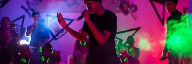 A man with a beanie singing on the stage.