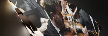 A man in black suit playing violin.
