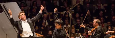 A conductor giving instructions to the orchestra.