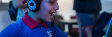 A boy on computer wearing a headset.