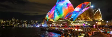 The Sydney Opera House lit up with colourful lights.