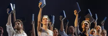 The cast wears neutral outfits, all holding up a book in their right hand