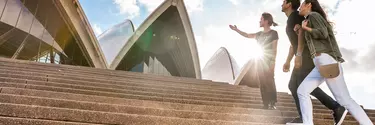 A tour guide outside Sydney opera house with a couple.