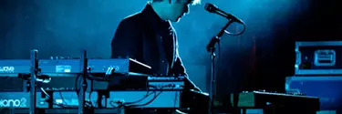 A man performing on a blue-lit stage.