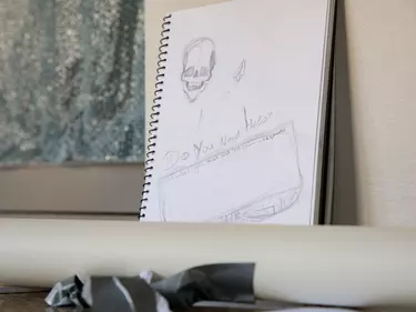 An open notebook with sketches of skulls in it.
