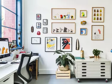 A wall of framed of colourful pictures.