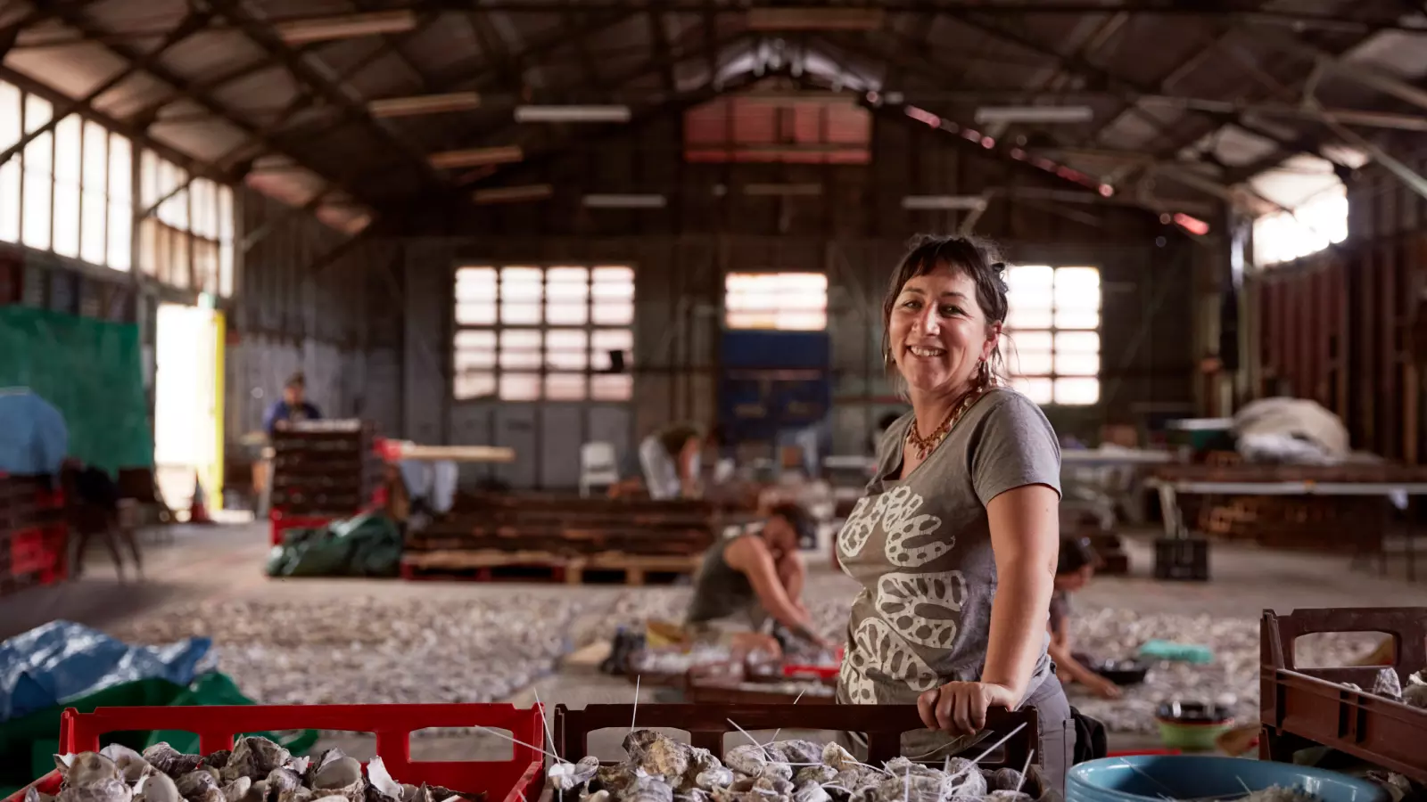 Megan Cope in a warehouse cleaning oyster shells.